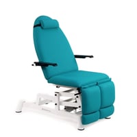 Elektrischer Podologiestuhl: dreiteilig, mit Höhenverstellung, Armlehnen, unabhängigen Beinstützen, Nackenstütze und kompensierter Trendelenburg-Lagerung.